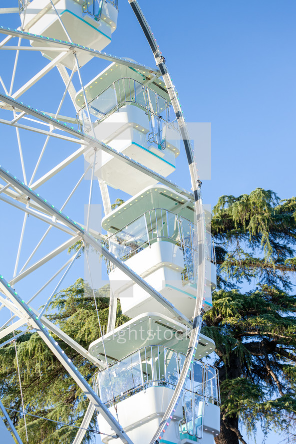 Ferris wheel on the blue sky background. Attraction present in amusement parks.