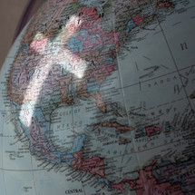 reflection of a cross on a globe over North America 