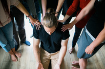 group laying hands on a man praying over him