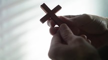 a person holding a wooden cross 