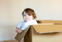 toddler girl in a cardboard box