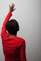 African-American woman with hand raised praising God 