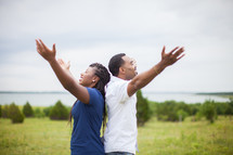 couple with raised hands praising God 