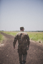 serviceman walking down a dirt road