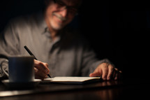 man writing in a journal 