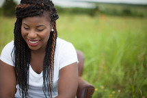 smiling African-American woman sitting in a chair outdoors 