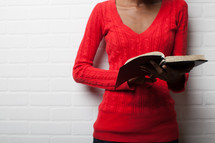 torso of an African-American woman reading a Bible 