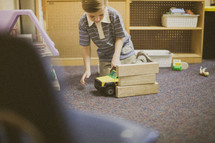 toddler boy playing with toys in a church nursery 
