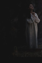 Mary praying in the stable next to the manger