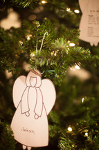 an angel ornament hanging on a Christmas tree