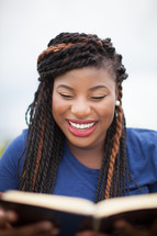 smiling African-American woman reading a Bible 