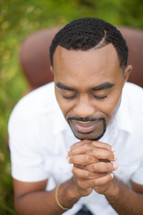 man in reverent prayer outdoors 
