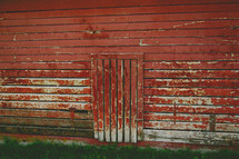 door to a weathered red barn 