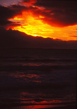 vibrant orange sky over ocean water at sunset