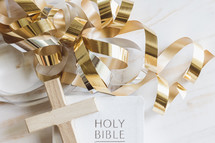 gold streamers cross, and Bible, on a white background