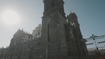 DOlly tilt up shot of bright sun behind Tower of Cathedral in Puebla,Mexico	