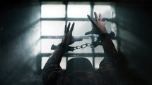 Prisoner in chains in front of a window