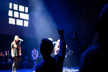 silhouettes of raised hands during a worship service