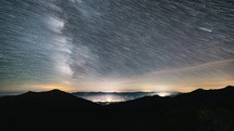 Startrails of Milky Way Galaxy in starry night sky in mountains Astronomy Time lapse, Star trails over Countryside traffic Night to day
