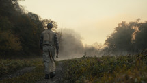 Young fly fisherman walking to a river at dawn