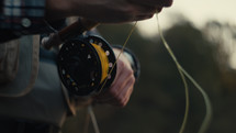 Young fly fisherman casting on a foggy river at sunrise