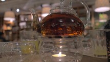 Glass teapot being heated with candle