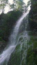 Slow motion of peaceful waterfall in green forest nature Vertical video
