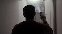 A Man is Examining the Dark House Using a Flashlight - Medium Shot	