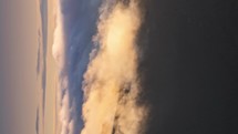 Vertical video of misty clouds motion fast over forest mountains nature at sunrise Time lapse
