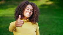 Stylish Woman With Hand Sign Like, Thumbs Up Gesture. Lady On Green Background
