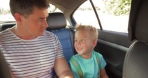 Cheerful father and son traveling by car