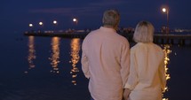 Senior couple in love by the sea at night