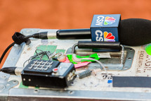News reporter gear and microphone with nbc in-ear on a box.