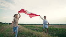 Swiss little kids - patriot children runs with national flag on nature background. Celebration banner, holidays, Switzerland, Republic Day, Independence Day, Carnival. High quality 4k footage