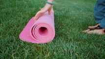 Woman rollling out yoga mat