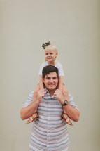 a daughter on her father's shoulders 