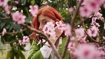 Girl smells spring pink flowers 