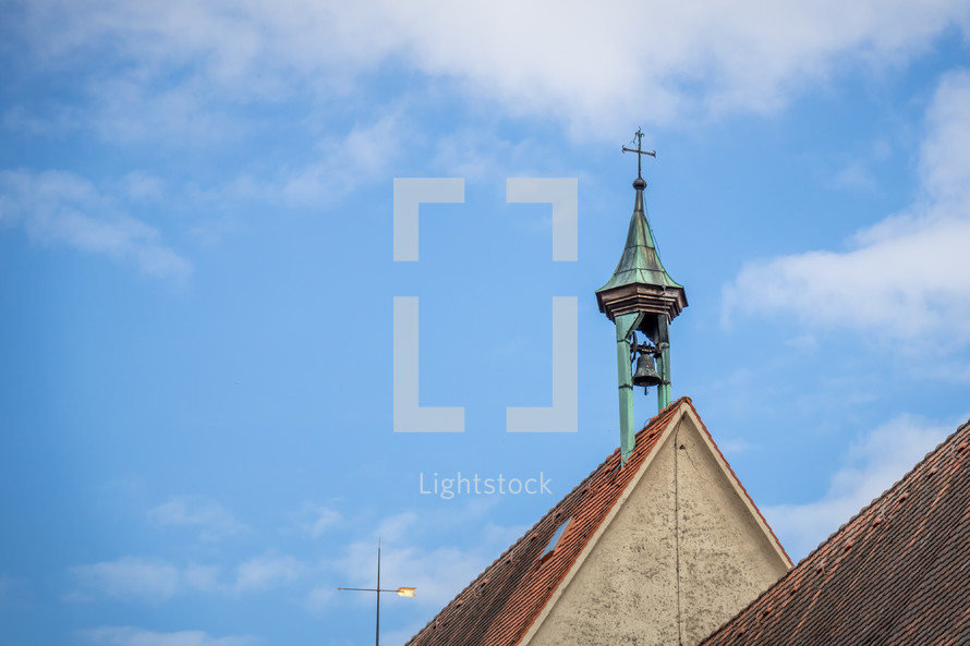 cross and bell on a church roof 