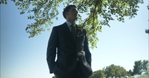 Groom, husband on wedding day wearing tux, suit and boutonniere on wedding day.