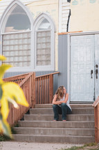 a woman sitting on church steps 