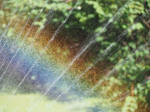 rainbow in droplets of water by rotating nozzle irrigation sprinkler aka a water sprinkler