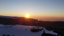 sunset over a snow covered mountaintop 