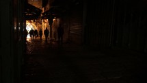 People silhouetted walking in the Jerusalem streets. 