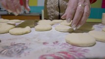Woman hands making donuts in a home kitchen - reverse, dolly view