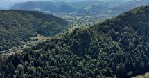 Mountain Peak With Dense Foliage In Romania On A Sunny Day. aerial drone