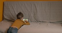 Child spending leisure with touch pad at home