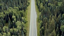 aerial view over a road and forest 