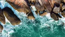 Aerial drone top down view bird eye view of sea blue waves break on rock.  Sea waves breaking over rocks. Amazing tropical sea wave. 