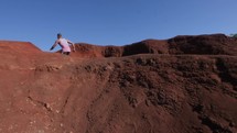 a man running up red sand slopes 