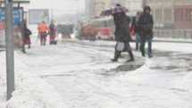 pedestrians walking on a snowy sidewalk 